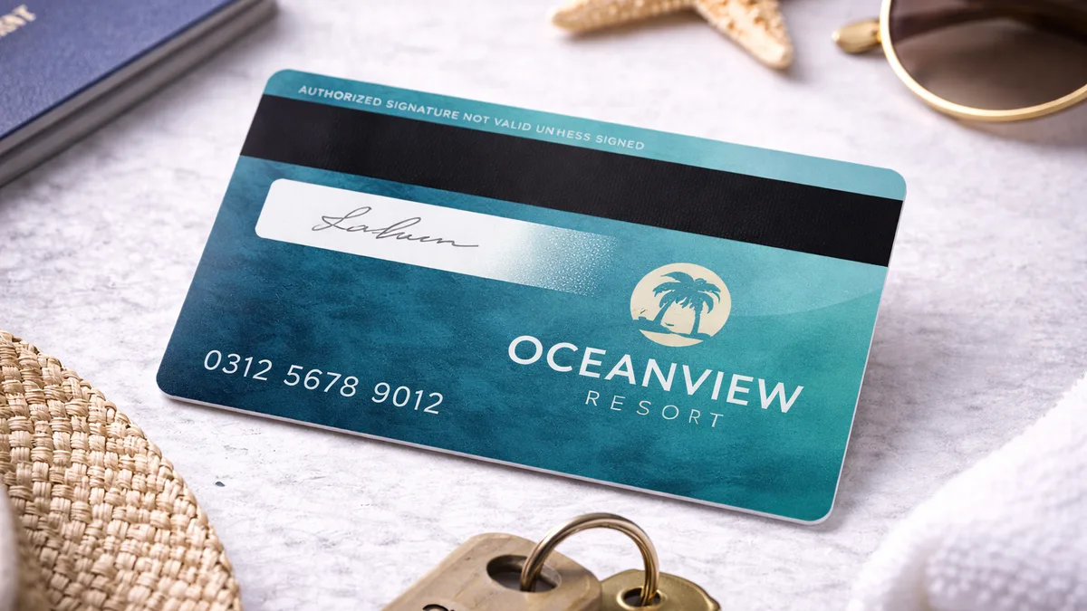 Carte d'hôtel en PVC à bande magnétique posée près d'une étoile de mer, de lunettes de soleil et d'une clé de chambre